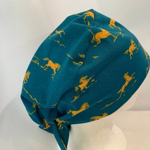 May include: Teal blue scrub hat with a pattern of yellow running horses.