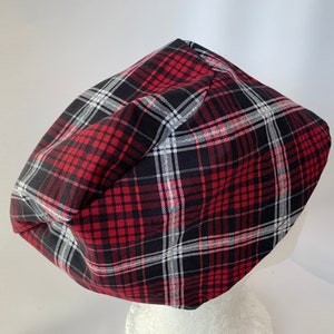 May include: A red, black, and white plaid fabric beanie hat.
