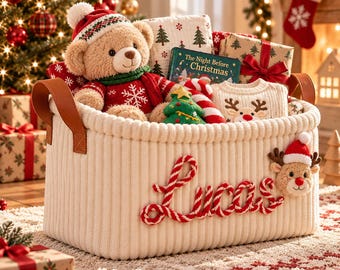 Peut inclure: Un panier de rangement en tissu côtelé crème avec le prénom Lucas écrit en lettres de corde torsadée rouge et blanche. Le panier contient un ours en peluche en pull rouge, un livre intitulé The Night Before Christmas et un pull renne.