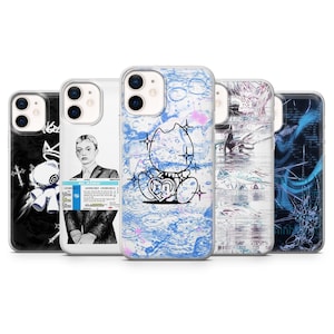 May include: Five phone cases arranged in a row. The first is black with a white cartoon character. The second is clear with a portrait of a person and text. The third is blue and white with a cartoon character. The fourth is abstract white and grey. The fifth is dark blue with abstract lines.