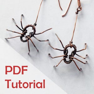 May include: Two copper wire spider earrings with a PDF tutorial. The spiders have eight legs and a round body.