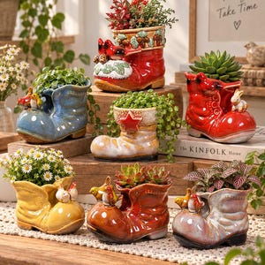 Op de afbeelding: Een collectie van zeven keramische laarsvormige plantenbakken in diverse kleuren zoals rood, blauw, geel en bruin. Elke laars is voorzien van decoratieve accenten zoals kleine vogels, konijnen of sterren en bevat verschillende kleine groene planten.