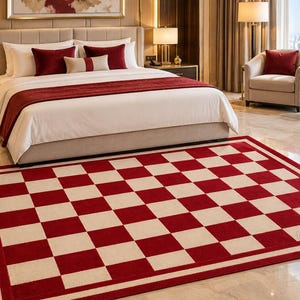 May include: A rectangular area rug featuring a bold red and cream checkerboard pattern with a solid red border. The rug displays the text "FamilyRugs" in the bottom right corner. The design consists of alternating square blocks in a grid.