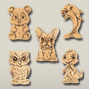May include: A collection of five light brown wooden cutouts featuring laser-engraved illustrations of a panda, a dolphin, a French bulldog, an owl, and a small dinosaur. Each piece displays detailed line work depicting the animal's features.