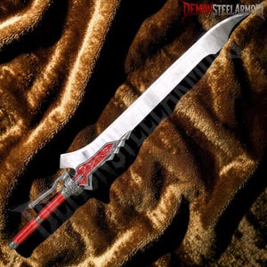 May include: A silver-coloured sword with a curved blade, featuring a red handle and a red decorative accent near the hilt with silver filigree details. The text DEMONSTEELARMORY is visible in the upper right corner of the image.