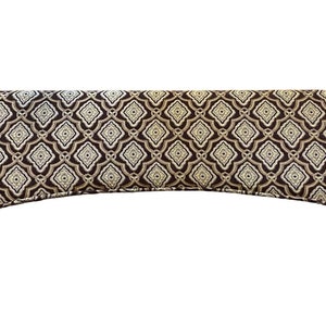 May include: A brown valance with a gold and white geometric pattern.