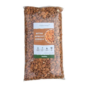 Puede incluir: Una bolsa de plástico transparente llena de huesos de albaricoque amargos de color marrón. La etiqueta blanca presenta el texto Coyote Herbs, Bitter Apricot Kernels, Raw & Natural y 2LB/907g, junto con cuatro iconos y una imagen circular.