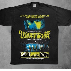 Pode incluir: Uma t-shirt preta de manga curta com uma impressão gráfica de 2001: Odisseia no Espaço. O design inclui um rosto de astronauta amarelo, o título do filme em inglês e japonês, uma cena de astronautas e três painéis menores com imagens.