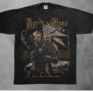 May include: A black short-sleeve t-shirt featuring a graphic of Geralt of Rivia holding a sword. The design includes the text "Geralt of Rivia" at the top, "Silver for Monsters + Steel for Humans" at the bottom, and additional descriptive text.