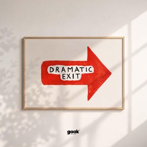 May include: A rectangular wall art print in a light wood frame featuring a bold red arrow pointing to the right. Centered on the arrow is a white, torn-edge paper strip with the black text DRAMATIC EXIT. The background is a solid off-white color.