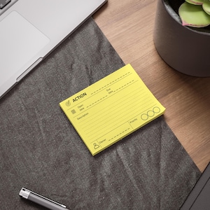 Peut inclure: Un bloc-notes adhésif rectangulaire jaune vif avec du texte et des icônes imprimés en noir. La mise en page comprend des champs pour ACTION, Due date, Open date, Description, Priority avec trois cercles vides et Owner, avec des lignes.