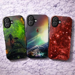 以下が含まれることがあります： 宇宙をテーマにしたアートワークが施された3つの長方形のスマートフォンケース。左のケースは緑色の星雲と宇宙飛行士のシルエット、中央のケースは宇宙船に繋がれた宇宙飛行士と「Project Hail Mary」の文字、右のケースは赤い星空と宇宙飛行士の姿が描かれています。