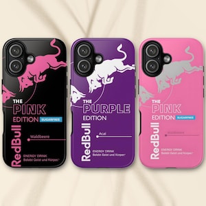 Peut inclure: Trois coques de smartphone arborant la marque Red Bull. La première est noire avec un taureau rose, la deuxième est violette avec un taureau blanc et la troisième est rose avec un taureau argenté. Chaque coque affiche le texte The Pink Edition ou The Purple Edition.