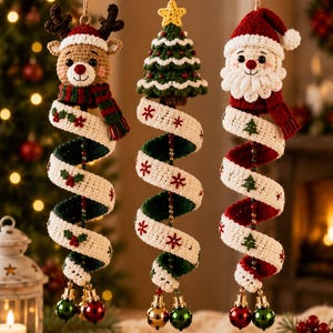 May include: Three hanging crochet ornaments featuring a reindeer, a Christmas tree, and Santa Claus. Each figure is attached to a spiralling white and green or red ribbon decorated with small embroidered motifs and finished with two metallic jingle bells.
