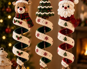 Könnte beinhalten: Drei hängende Häkelornamente mit einem Rentier, einem Weihnachtsbaum und dem Weihnachtsmann. Jede Figur ist an einem spiralförmigen, weiß-grünen oder roten Band befestigt, das mit kleinen gestickten Motiven verziert und mit zwei Metallglöckchen versehen ist.