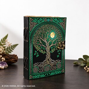 Könnte beinhalten: Ein schwarzes Notizbuch mit einer grün-goldenen Lebensbaum-Illustration auf dem Einband, inklusive Vollmond, komplexen Blattmustern, einem Metallverschluss und sichtbaren seitlichen Bindestichen. Der Text 2026 VEERA. All rights reserved. ist vorhanden.
