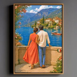 May include: A framed wall art print depicting a view of a lake with mountains in the background. Two figures stand on a stone terrace overlooking the water, one in a coral dress and one in a white shirt and blue trousers. A small boat is on the water.