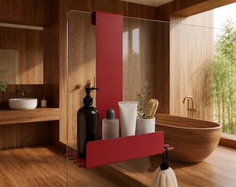 Op de afbeelding: Een matrood douche-opbergrek voor over een glazen wand, voorzien van een verticale beugel, een horizontale plank en geïntegreerde haken. Op de plank staan een donkerbruine pompflacon, een matglazen flesje, een witte tube en een houten borstel.