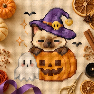May include: A cross-stitch embroidery on beige fabric featuring a Siamese cat wearing a purple witch hat with a yellow skull, sitting inside a carved orange pumpkin next to a small white ghost, surrounded by orange stars and black bats.