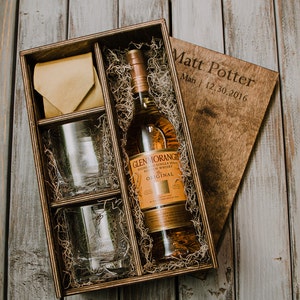 May include: A wooden gift box with a bottle of Glenmorangie Original Single Malt Scotch Whisky, two glasses, and a yellow necktie. The box is engraved with the text "Matt Potter, Matt, 12.30.2016".