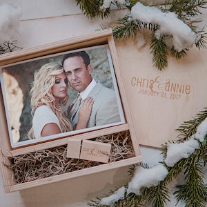 May include: A wooden box with a photo of a couple inside. The box is engraved with "Chris & Annie January 21, 2017". A small wooden USB drive is also inside the box.