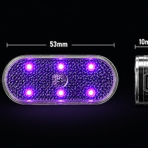 May include: An oval-shaped light with a textured surface emitting a purple glow from six internal points. The device measures 53mm in length, 27mm in height, and 10mm in depth, featuring a side port for charging or connectivity.