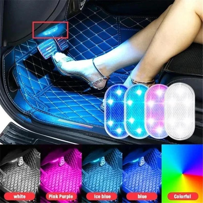 May include: A set of oval-shaped LED car interior footwell lights featuring a textured surface. The lights are shown in white, pink-purple, ice blue, and blue, with a color spectrum option. These lights are installed in a vehicle floor area.