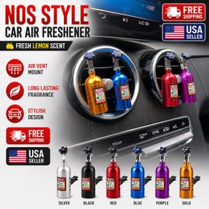 May include: A collection of NOS style car air fresheners shaped like miniature nitrous oxide tanks. The fresheners are available in silver, black, red, blue, purple, and gold metallic finishes, each featuring a small nozzle and a label with the text NOS.