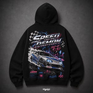 以下が含まれることがあります： 背面にグラフィックプリントが施された黒いフード付きスウェットシャツ。デザインには、銀色のスポーツカー、SPEED DEMONの文字、日本語の文字、チェッカーフラッグ、暗い街並みを背景にした青い稲妻のアクセントが描かれています。
