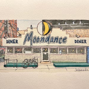 Könnte beinhalten: Eine Aquarellillustration des Moondance Diner mit einem gelben Mondsichel-Schild, blauer Schrift und einem davor geparkten Fahrrad. Die Gebäudefassade zeigt Fenster mit kleinen Mondaufklebern und den Schriftzug Moondance Diner.