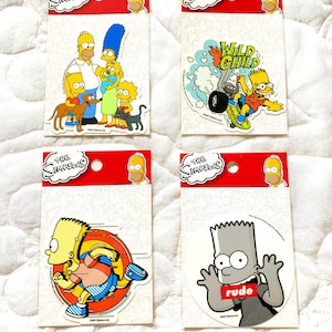 May include: Four Simpsons character stickers on white card stock. The stickers feature Bart Simpson running, Bart Simpson with the word "rude" on a red banner, the Simpsons family, and Bart Simpson riding a motorcycle with the words "Wild Child".