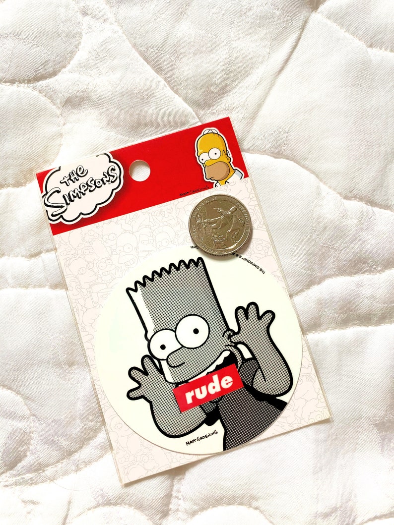May include: A white sticker with a black and white cartoon image of Bart Simpson from The Simpsons. Bart is wearing a black shirt with the word "rude" in red letters across the front. The sticker is on a white background with a small image of Homer Simpson in the top right corner.
