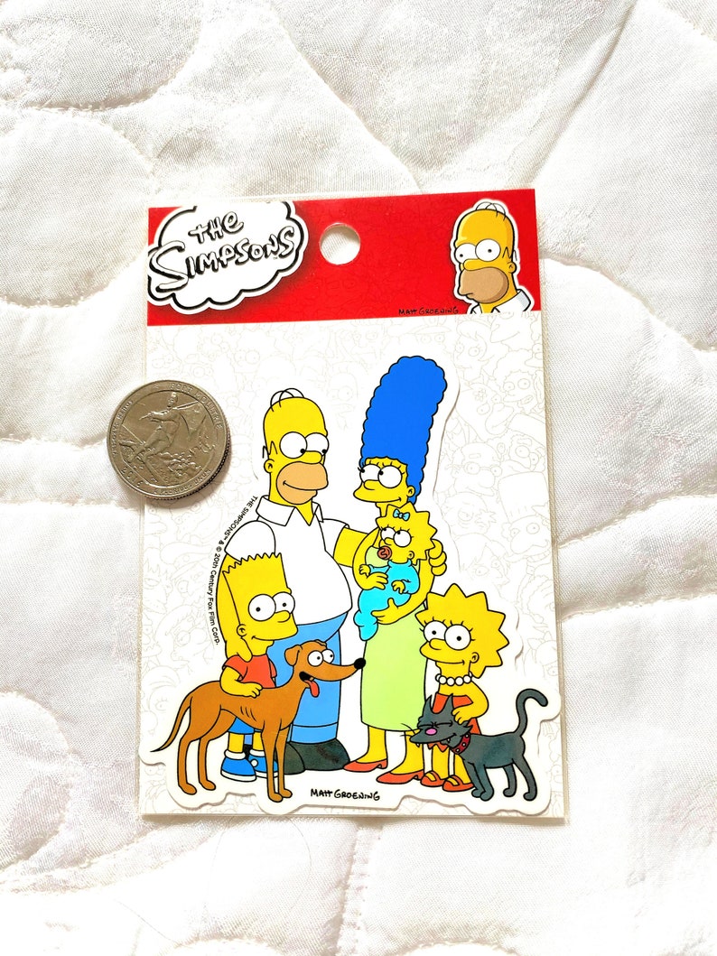 May include: A sticker sheet featuring the Simpsons family. The sticker sheet is red and white with the words "The Simpsons" in a white cloud. The sticker sheet includes Homer, Marge, Bart, Lisa, Maggie, Santa's Little Helper, and Snowball.