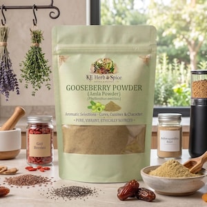 Może przedstawiać: Jasnozielona torebka stojąca z proszkiem z agrestu KE Herb & Spice, znanym również jako proszek Amla. Etykieta zawiera tekst 'Gooseberry Powder (Amla Powder) (Phyllanthus emblica)', 'Aromatic Selections - Cures, Cuisines & Character' oraz 'Pure, Vibrant, Ethically Sourced'.