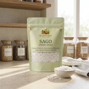 Könnte beinhalten: Ein hellgrüner Standbeutel mit der Aufschrift KE Herb & Spice Sago (Pearl Sago) und einem Sichtfenster, das weiße Sago-Perlen zeigt. Der Text lautet Aromatic Selections - Cures, Cuisines & Character. - PURE, VIBRANT, ETHICALLY SOURCED. Eine kleine Schale mit Sago steht davor.