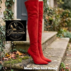 Op de afbeelding: Een paar rode over-de-knie laarzen met een puntige neus en een dunne stilettohak. De laarzen hebben een zachte, suède-achtige textuur. Tekst op de afbeelding bevat "In 3 Colours", "Glamzonia CREATIONS" en "Mens Plus Size Boots".