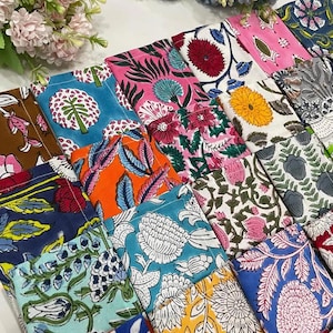 Puede incluir: Una colección de posavasos cuadrados de tela con una variedad de coloridos estampados florales y botánicos en tonos azul, rosa, naranja, amarillo y verde, dispuestos en una cuadrícula con costuras blancas visibles en cada pieza.