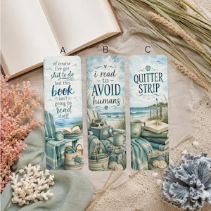 May include: Three rectangular bookmarks labeled A, B, and C featuring coastal scenes. Bookmark A says, of course I've got shit to do but this book isn't going to read itself. Bookmark B says, i read to AVOID humans. Bookmark C says, QUITTER STRIP.