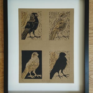 K&ouml;nnte beinhalten: Ein gerahmter Druck auf beigefarbenem Papier mit vier verschiedenen Vogelillustrationen in schwarzer Drucktechnik. Das Kunstwerk befindet sich in einem schlichten schwarzen Rahmen mit wei&szlig;em Passepartout. Jeder Vogel zeigt individuelle Texturen.