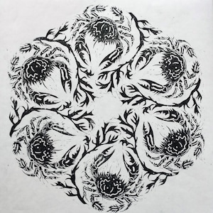 Circular black and white linocut art repeat print featuring six velvet swimming crabs and seaweed fronds arranged in a rotating, radial mandala pattern printed in black ink on white Japanese washi paper.
