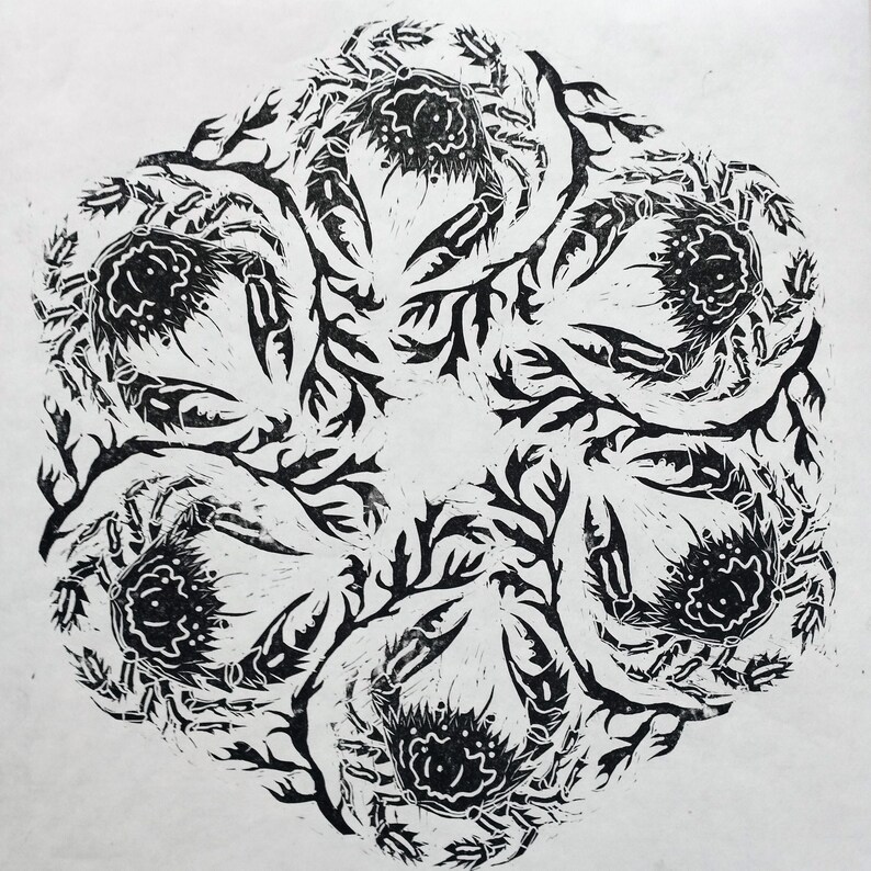 Circular black and white linocut art repeat print featuring six velvet swimming crabs and seaweed fronds arranged in a rotating, radial mandala pattern printed in black ink on white Japanese washi paper.