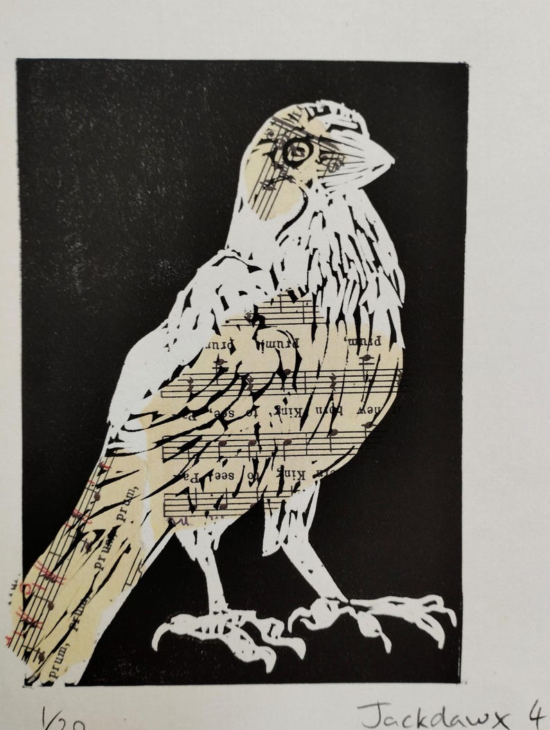 K&ouml;nnte beinhalten: Ein schwarz-wei&szlig;er Druck mit der stilisierten Silhouette eines Vogels vor einem einfarbigen schwarzen Hintergrund. Der K&ouml;rper des Vogels besteht aus cremefarbenem Papier, das mit Noten und Text bedruckt ist. Unten steht der Text "Jackdawx 4".