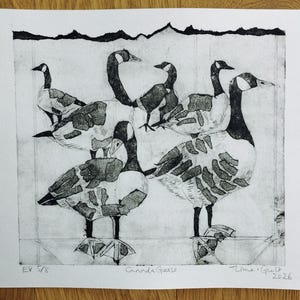 Pode incluir: Uma impress&atilde;o a preto e branco em papel apresentando um grupo de gansos-do-canad&aacute; com padr&otilde;es texturizados em forma de blocos nos seus corpos. A obra inclui o texto manuscrito "EV 5/8", "Canada Geese" e uma assinatura com a data "2026".