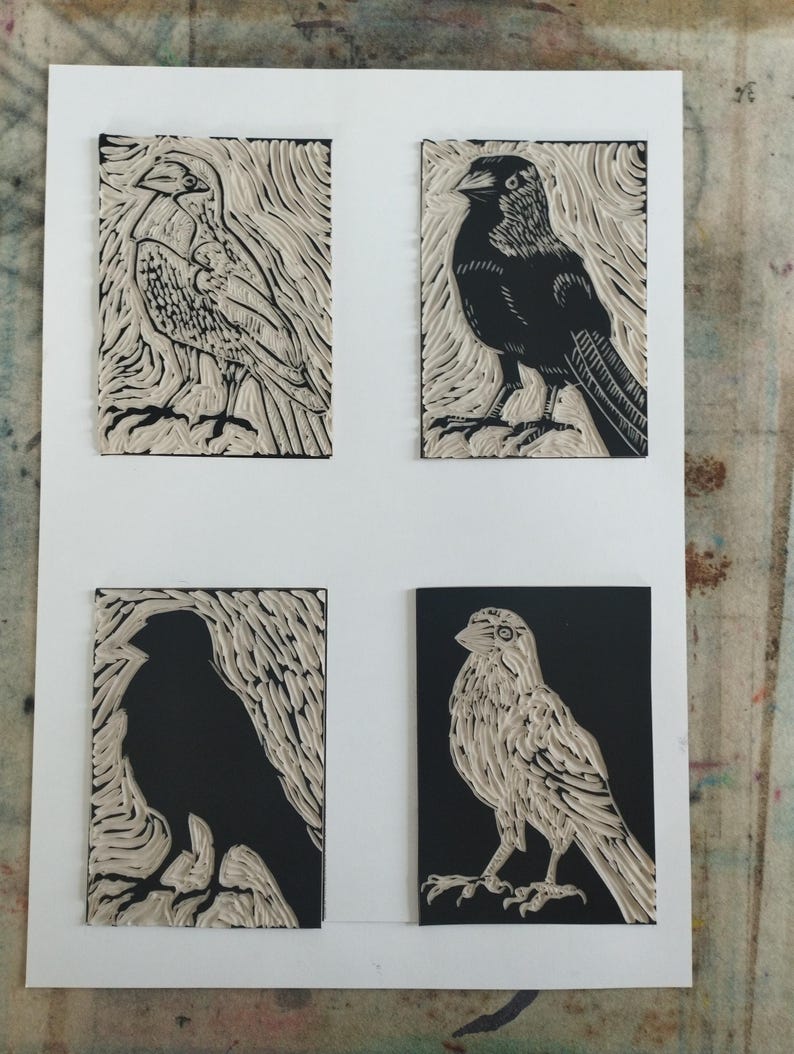 K&ouml;nnte beinhalten: Ein wei&szlig;es Blatt Papier mit vier rechteckigen Linoldrucken von V&ouml;geln. Jeder Druck zeigt einen anderen Vogel in einem kontrastreichen Schwarz-Wei&szlig;-Stil und verwendet geschnitzte Texturen, um das Gefieder und die Hintergrundmuster zu definieren.