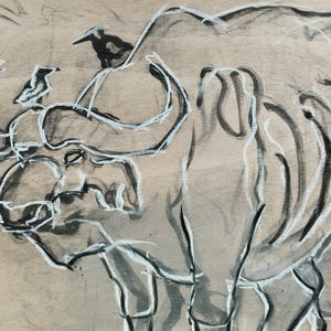 May include: A charcoal and white ink drawing on tan paper depicting a large buffalo with curved horns. Two small birds are perched on the buffalo's back and head. The artwork uses expressive, loose lines to define the animal's form and features.