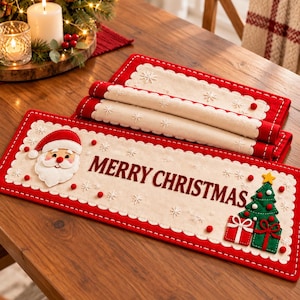 Pode incluir: Um caminho de mesa retangular de feltro com centro creme e o texto MERRY CHRISTMAS em letras vermelho-escuras. O caminho tem uma borda vermelha, uma aplicação de Pai Natal, uma árvore verde e pequenos pompons vermelhos.