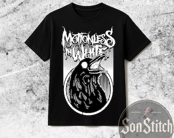 Könnte beinhalten: Ein schwarzes Kurzarm-T-Shirt mit einem weißen Grafikdruck eines Raben in einem kreisförmigen Rahmen. Über dem Vogel steht der Text "MOTIONLESS IN WHITE" in einer stilisierten, gezackten Schriftart. Das Design ist mittig auf der Vorderseite.
