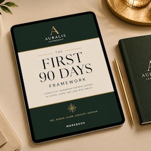 以下が含まれることがあります： Auralis Leadershipによる「The First 90 Days Framework」というタイトルのワークブックを表示したデジタルタブレット。表紙はダークグリーンとクリーム色で、金色のアクセント、コンパスのアイコン、および「See, Assess, Align, Execute, Sustain」というテキストが記載されています。