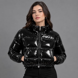 May include: A black puffer jacket with a high collar and a glossy, patent-like finish. The jacket features horizontal quilted panels, a full-length front zipper, and elasticized cuffs. The design includes two side pockets and a cropped silhouette.