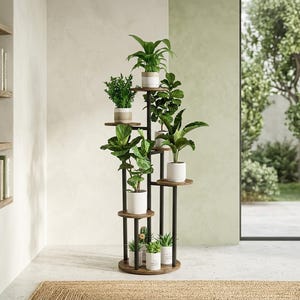 May include: A multi-tiered plant stand featuring a central black metal frame with circular wooden shelves at varying heights. The stand holds several potted green plants in white and neutral-toned ceramic pots, arranged in a vertical, staggered display.